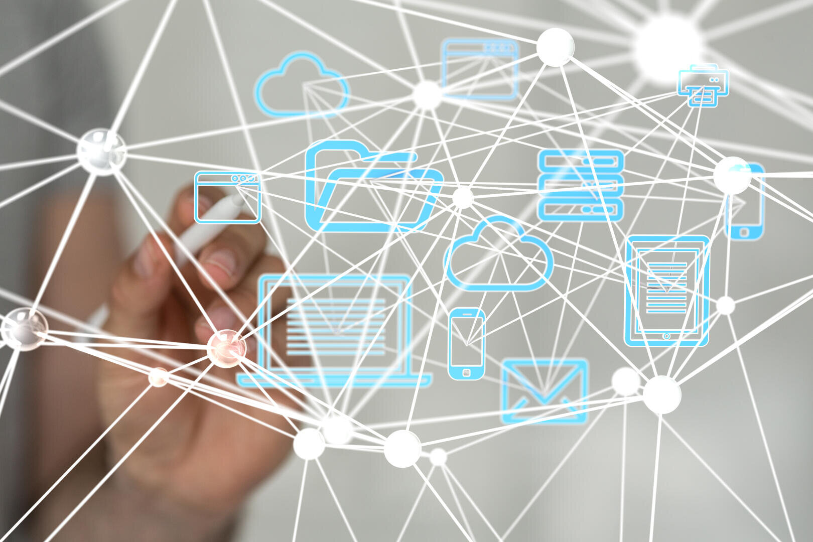 Die Hand einer Person berührt einen transparenten Bildschirm, auf dem miteinander verbundene digitale Symbole zu sehen sind, darunter ein Laptop, ein Smartphone, eine Cloud und E-Mail, die digitale Konnektivität und Netzwerkkommunikation symbolisieren.